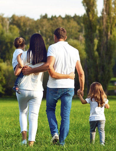 Rear view. Happy family with children walking in the park.